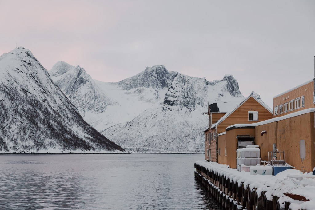 Mountains, ocean, docks and part of the Br. Karlsen production facility on Husøya, Senja